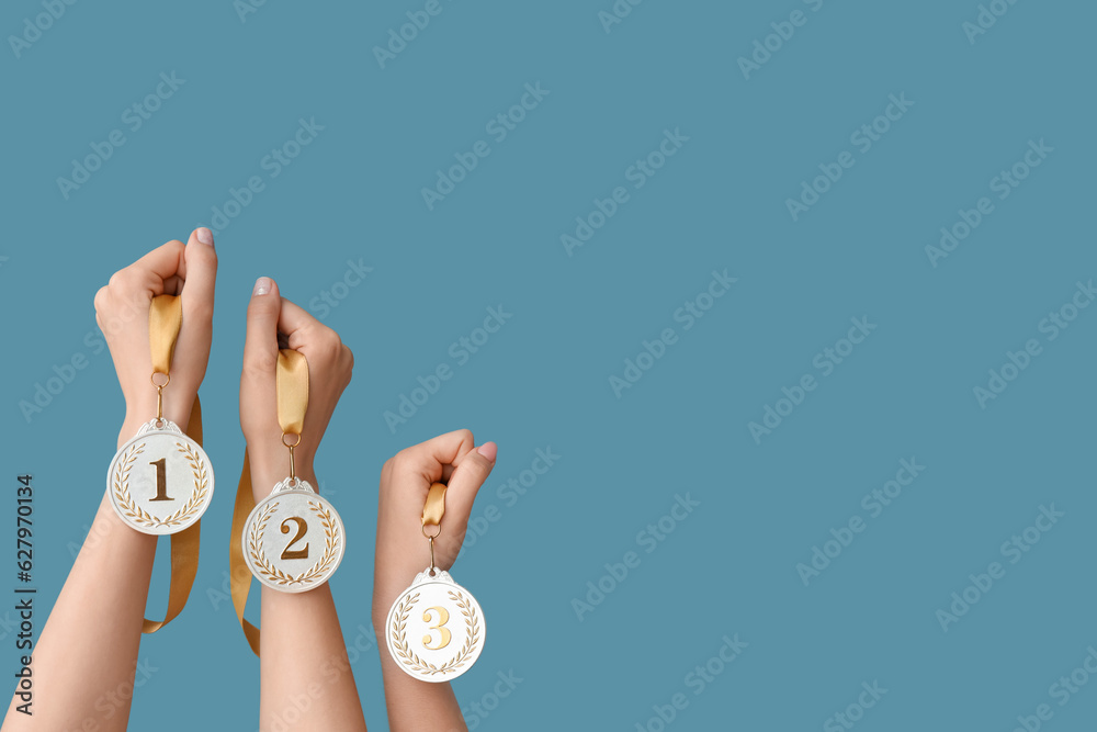 Female hands with medals on blue background