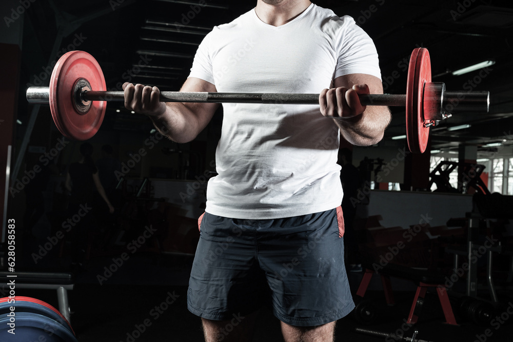 Male athlete lifts the barbell