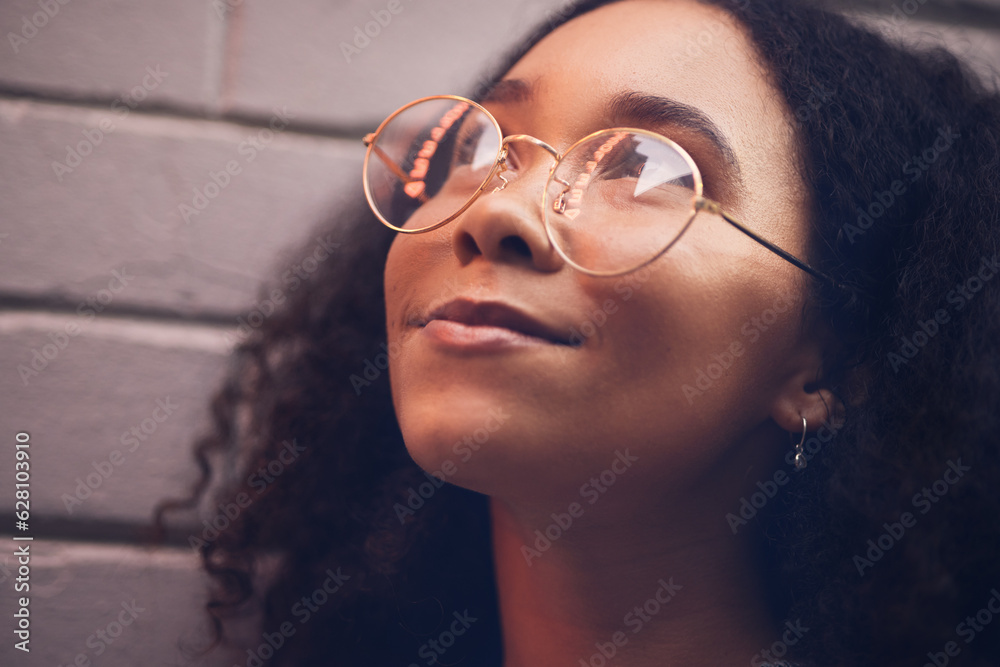 .Face, thinking and glasses with a black woman in the city at night against a brick wall closeup for