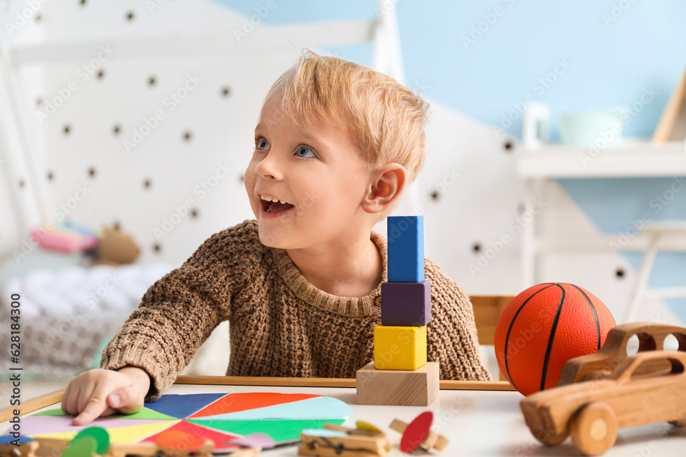 Cute little boy playing with toys at home