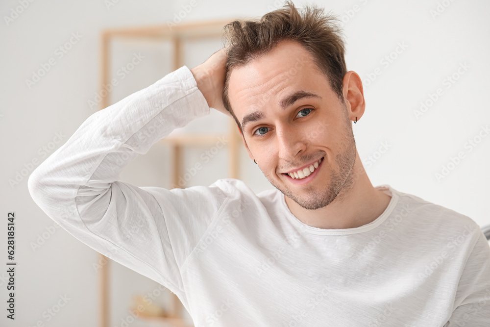 Young man with hair loss problem in bathroom, closeup