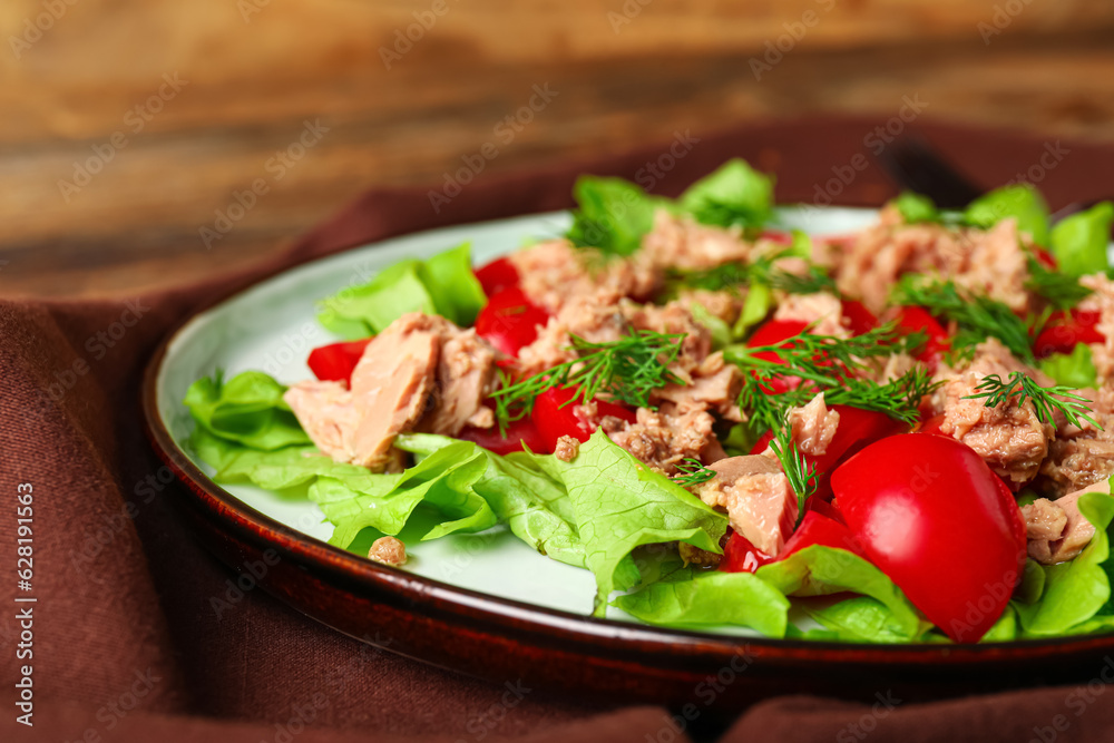 Plate with delicious tuna salad on wooden table, closeup