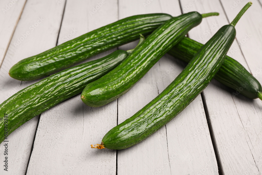 Fresh cucumber on light wooden background