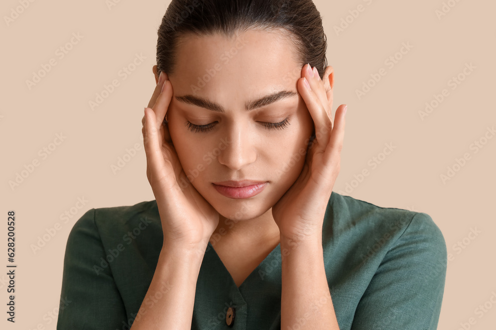 Thoughtful young woman on beige background, closeup