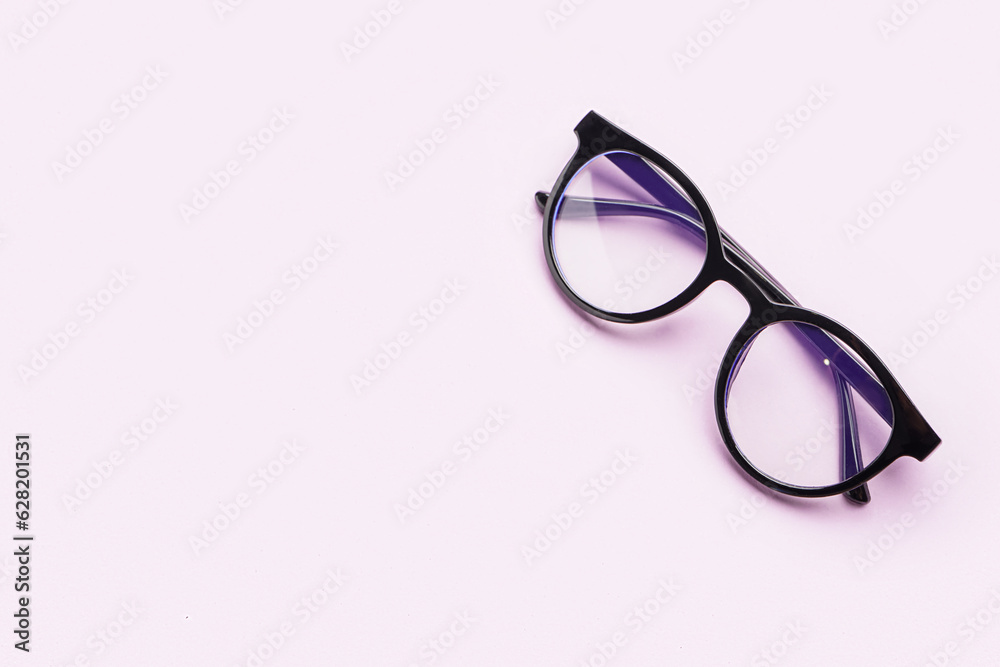 Stylish black eyeglasses on lilac background