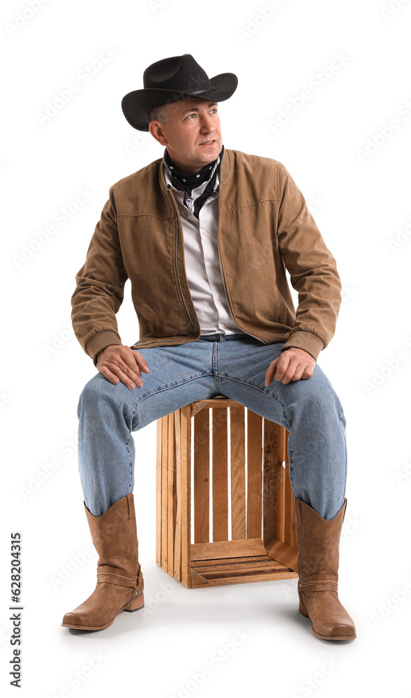 Mature cowboy sitting on white background