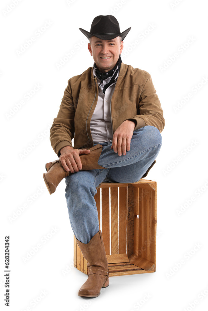 Mature cowboy sitting on white background