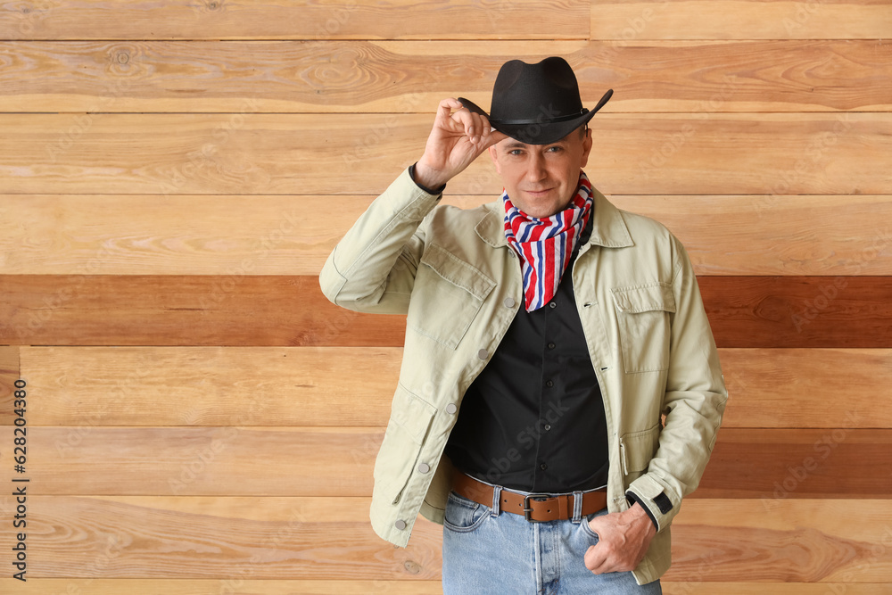 Mature cowboy on wooden background