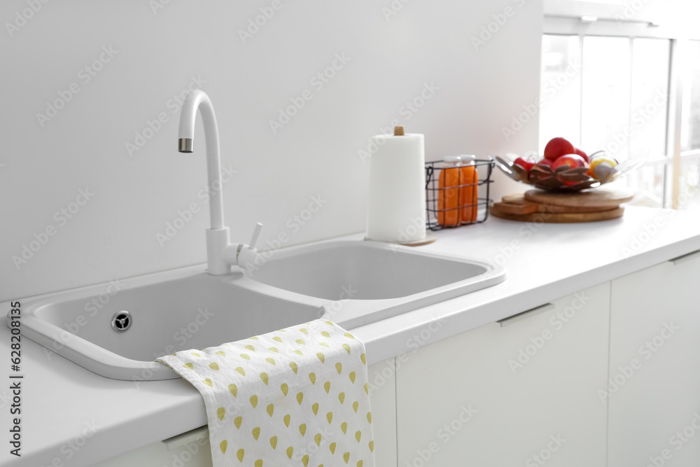 White kitchen counters with sink and faucet, closeup