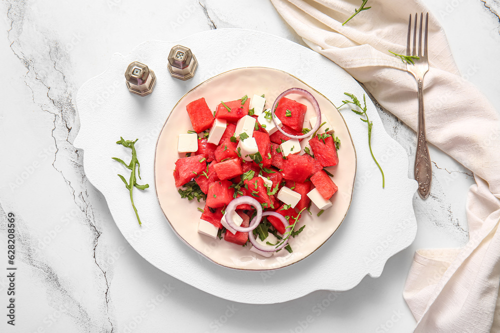 Plate of tasty watermelon salad on white marble background