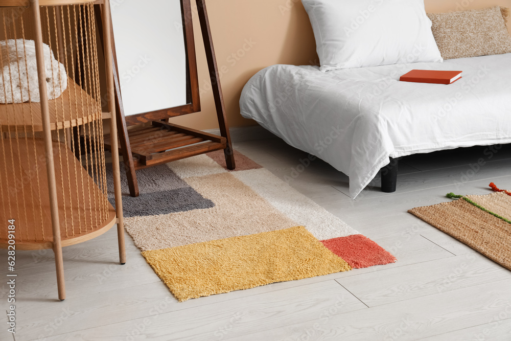 Stylish rug in interior of cozy bedroom