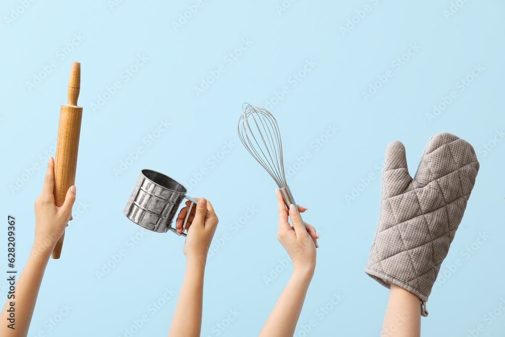 Female hands with baking utensils on blue background