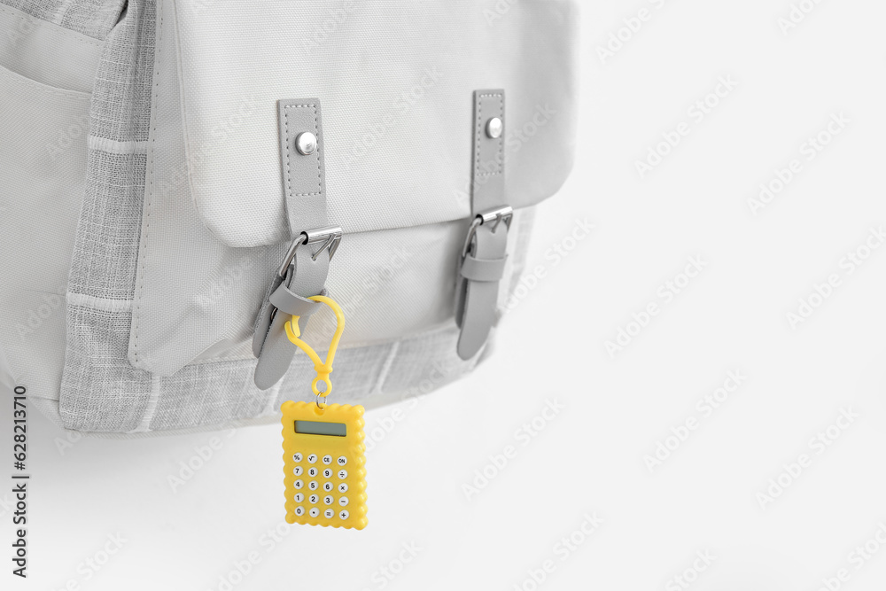 Grey school backpack with stationery on white background