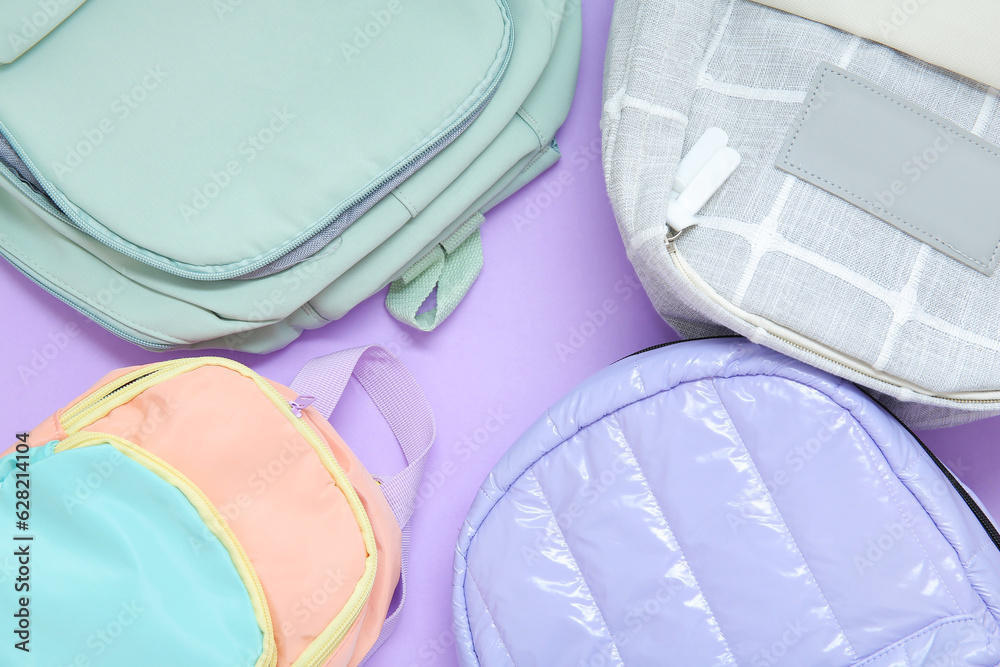 School backpacks on purple background