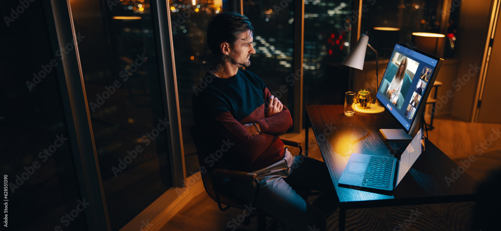 Professional businessman having a virtual meeting with his colleagues at night