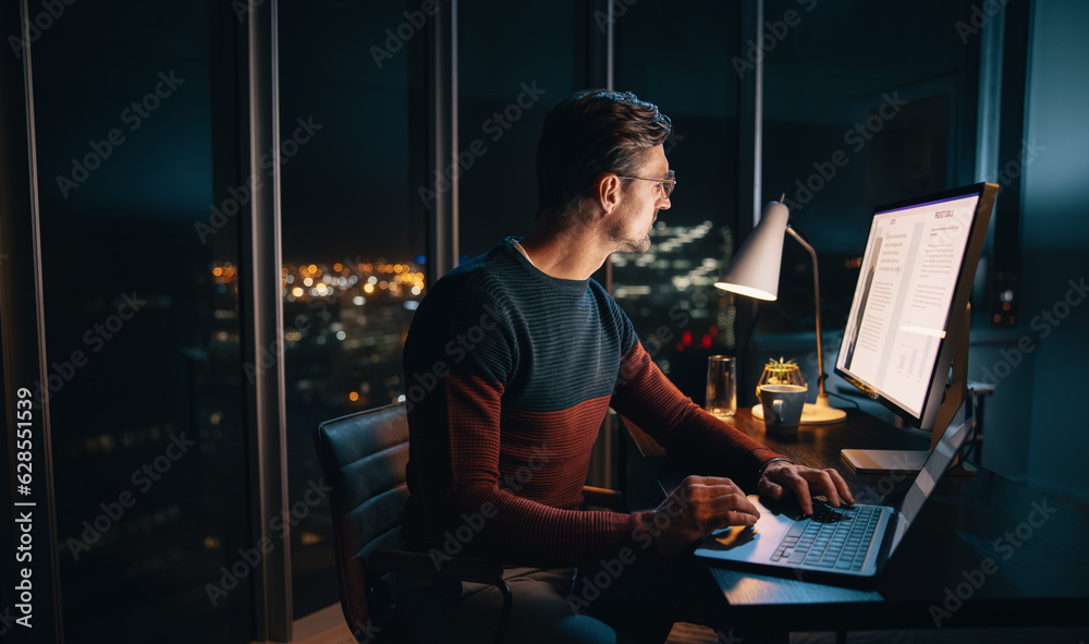 Late night marketing plan: Professional man typing on laptop in office