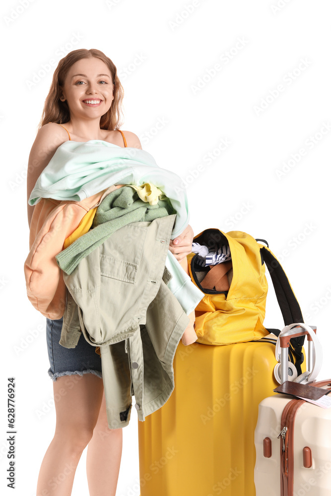 Young woman packing her clothes in backpack on white background