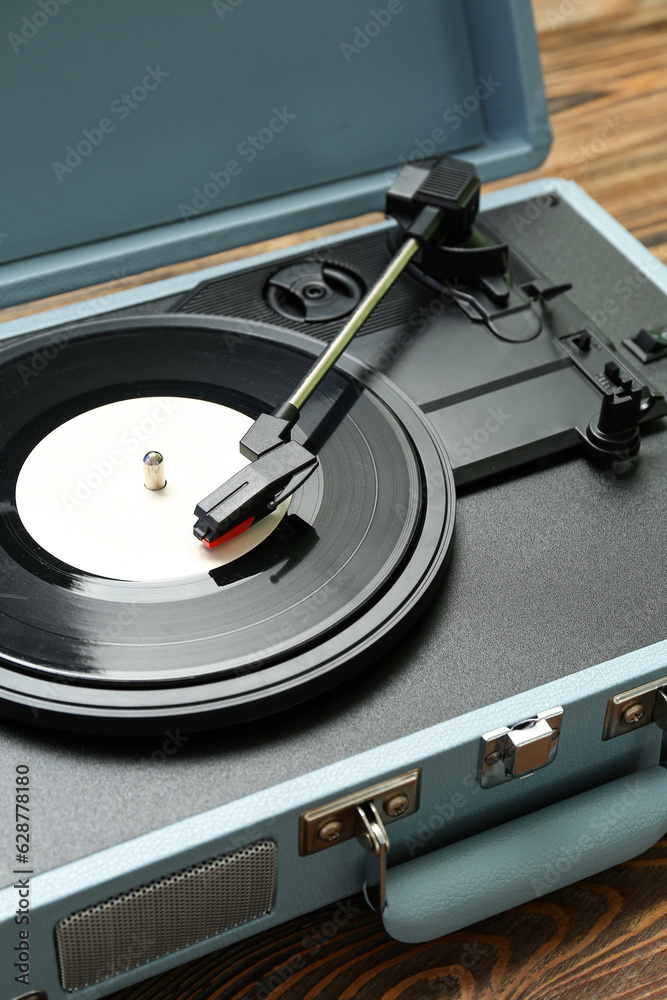 Record player with vinyl disk on wooden background, closeup