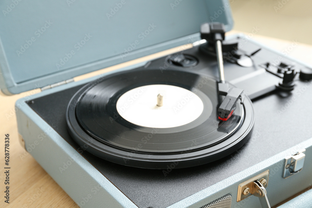 Record player with vinyl disk on table in room, closeup