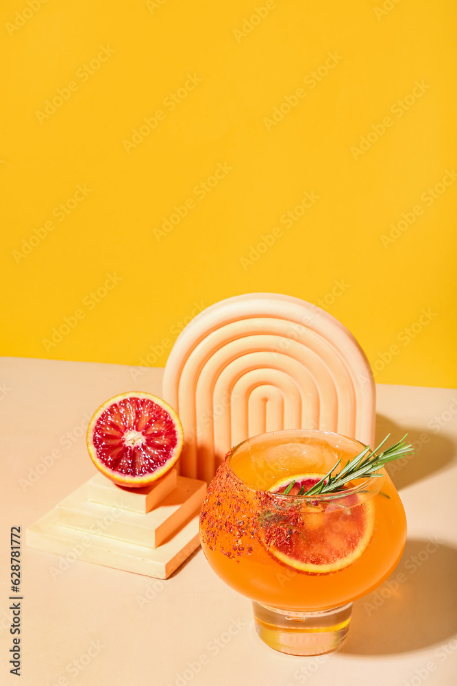 Fresh summer cocktail with grapefruit and rosemary on orange background