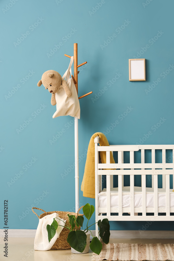 Interior of bedroom with baby crib and rack