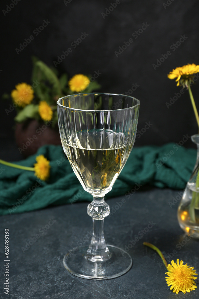 Glass of dandelion wine on dark table