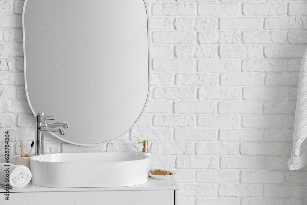 White sink with bath accessories on table in bathroom