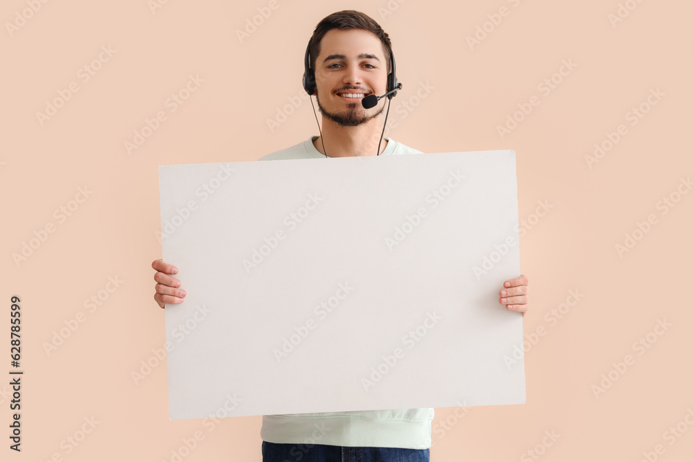 Male technical support agent with blank poster on beige background