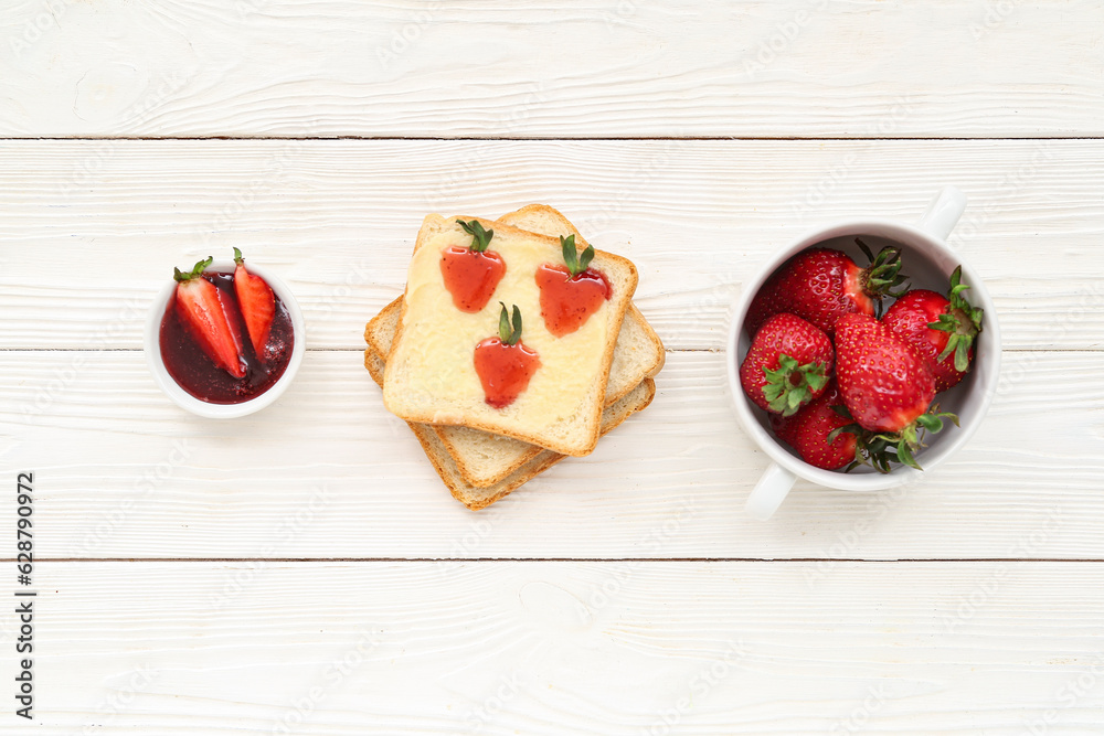 Tasty toasts with sweet strawberry jam and fresh berries on white wooden background