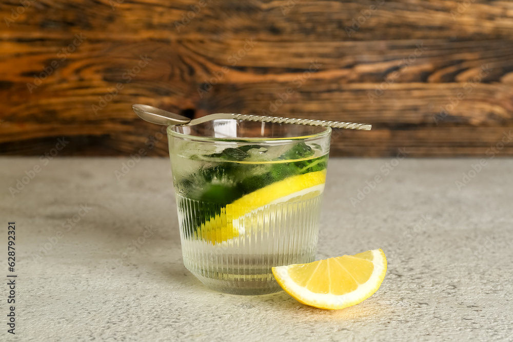 Glass of lemonade with cucumber on white table