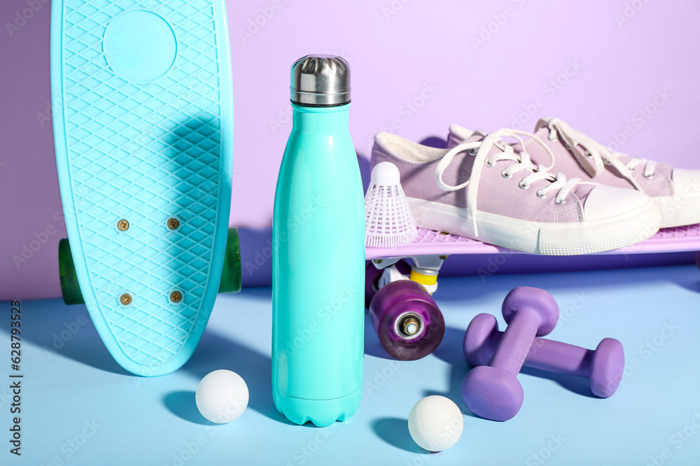 Composition with sports equipment, shoes and bottle of water on color background