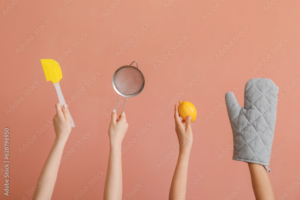 Female hands with baking utensils on pink background