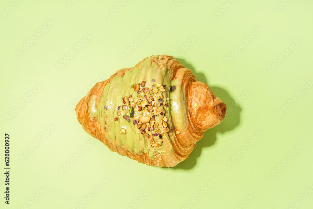 Sweet croissant on green background