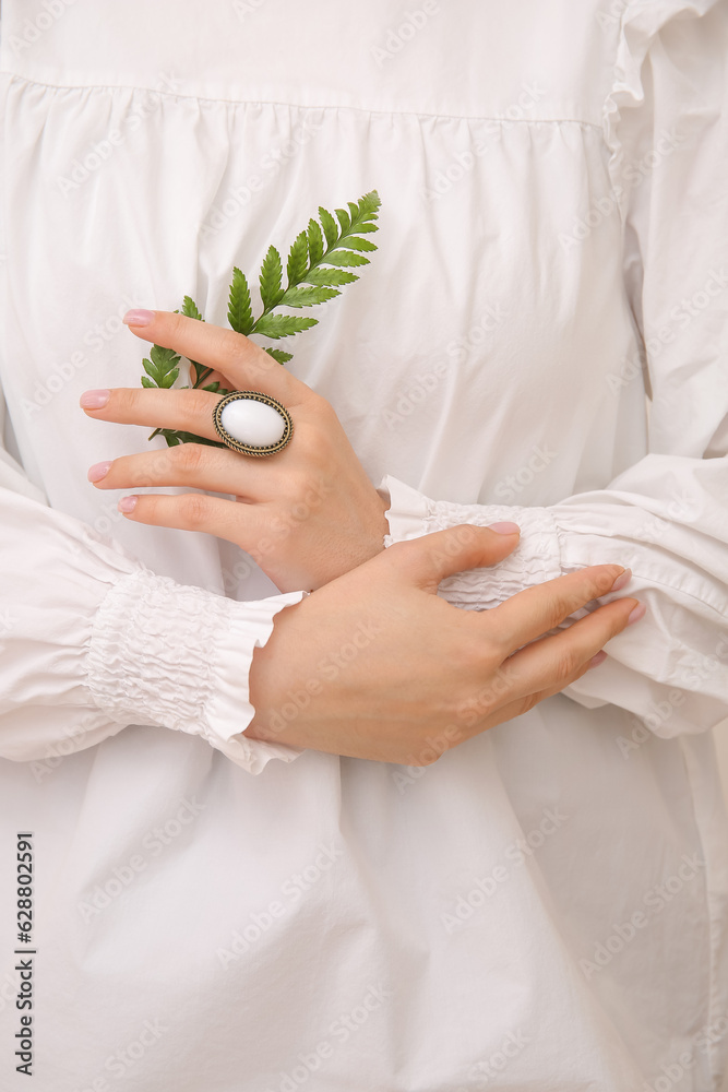 Woman with beautiful vintage ring and plant branch, closeup