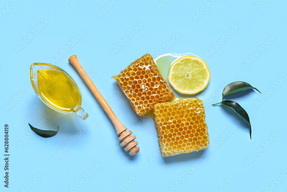 Gravy boat with sweet honey and combs on blue background