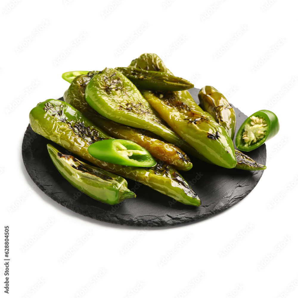 Slate board with grilled chili peppers on white background