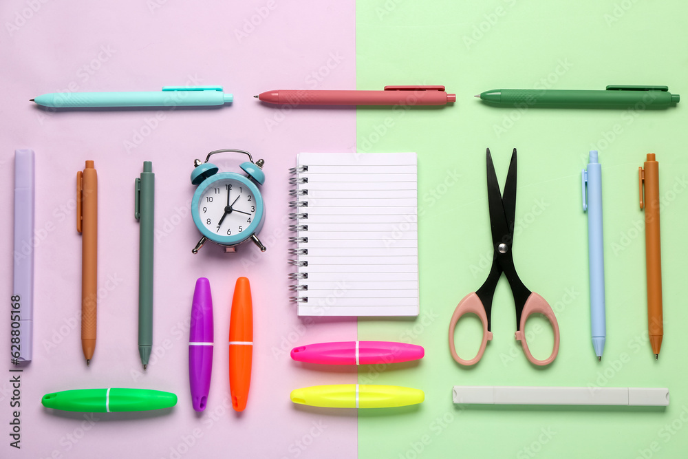 Notebook with different stationery supplies on colorful background