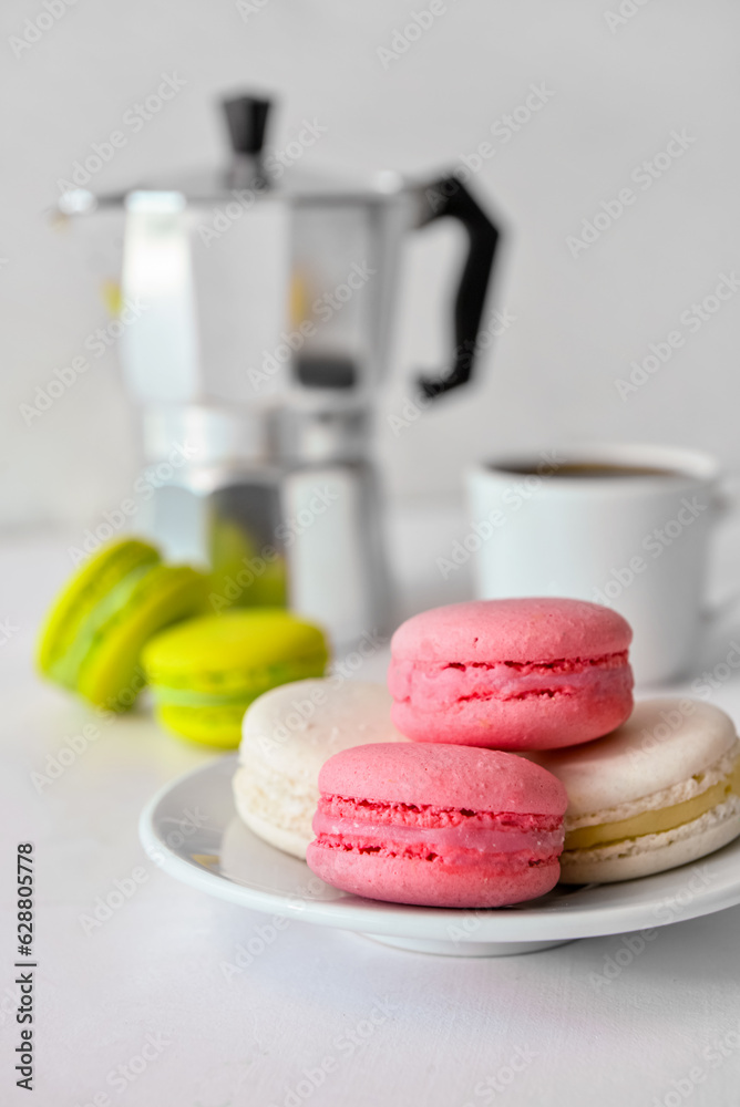 Plate with sweet macaroons on white background