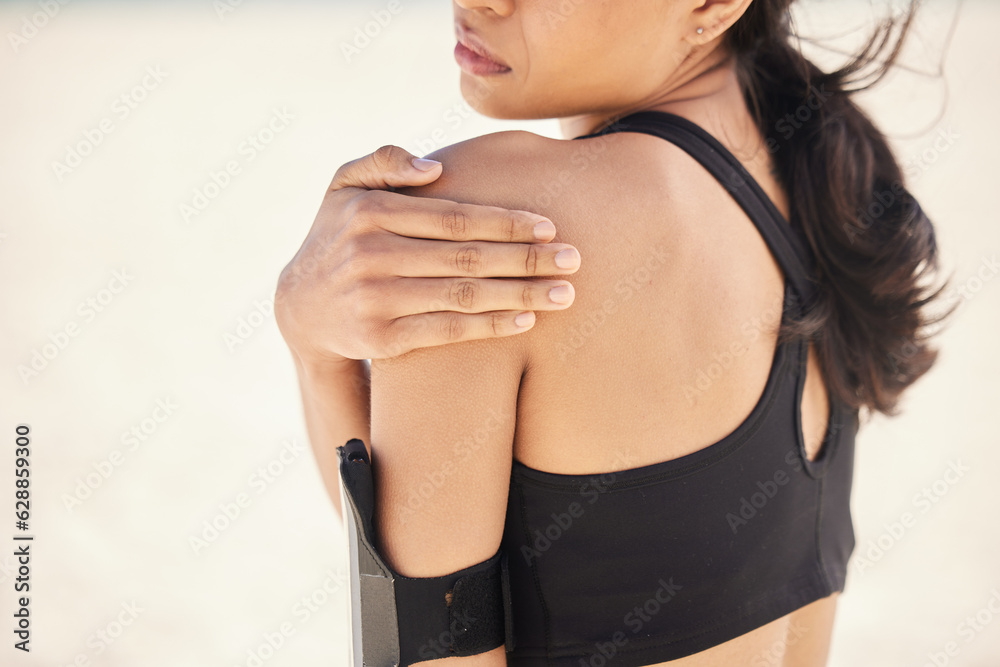 Fitness, shoulder pain and running with woman on beach for sports injury, inflammation and accident.