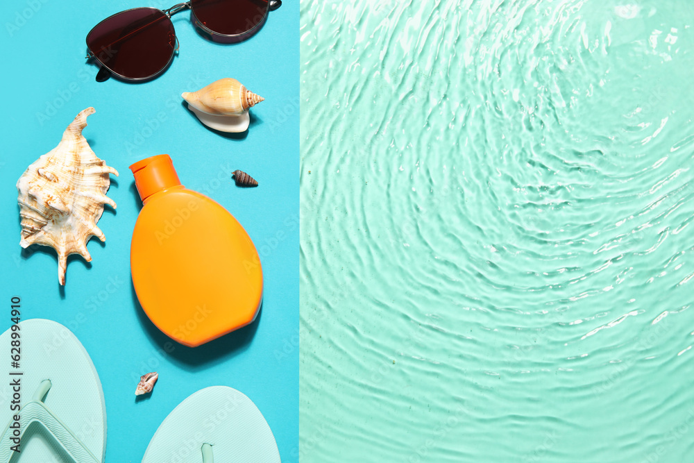 Bottle with sunscreen cream, sunglasses and flip flops on edge of swimming pool