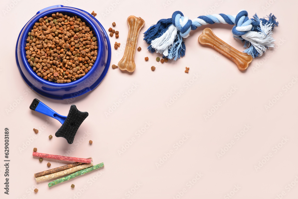 Composition with bowl of dog food and accessories on light background