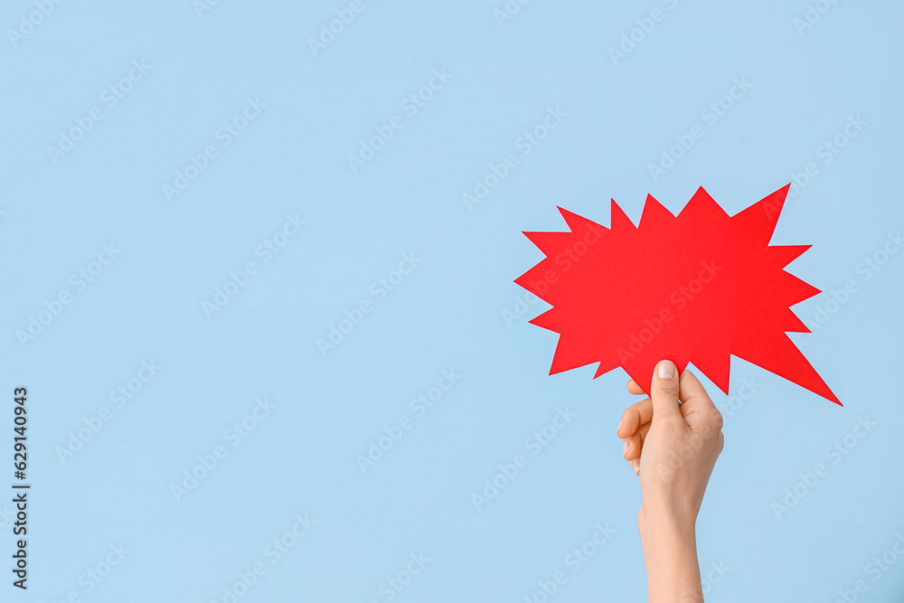 Female hand with speech bubble on blue background