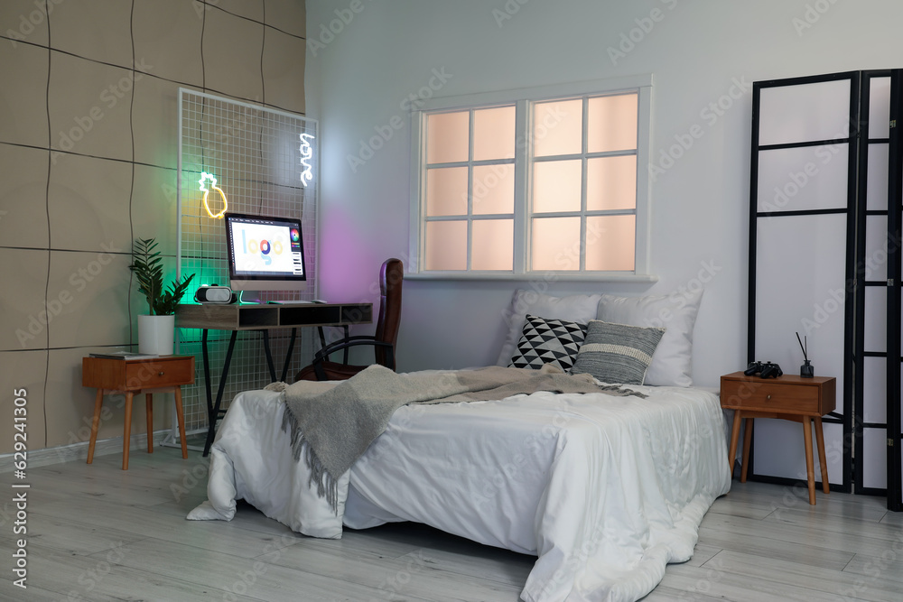 Interior of childrens bedroom with cozy bed and modern computer on table