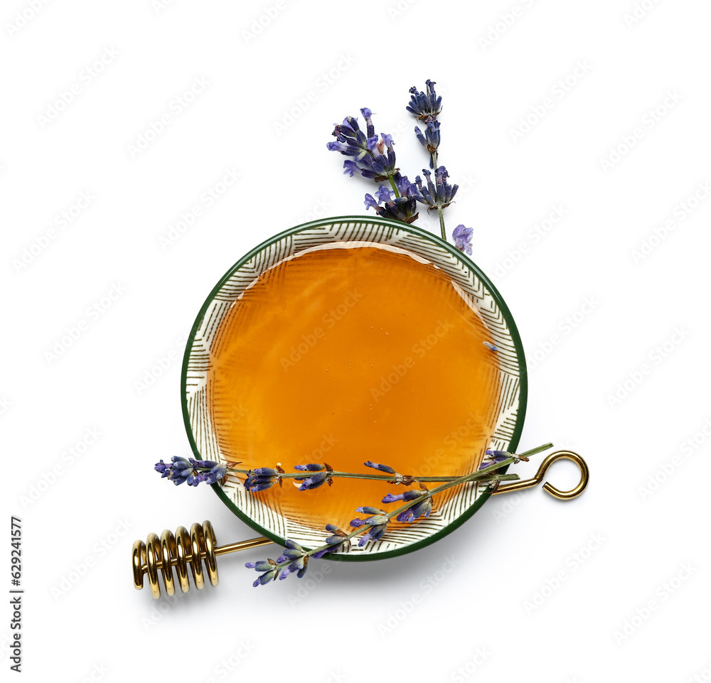 Bowl of sweet lavender honey, dipper and flowers on white background