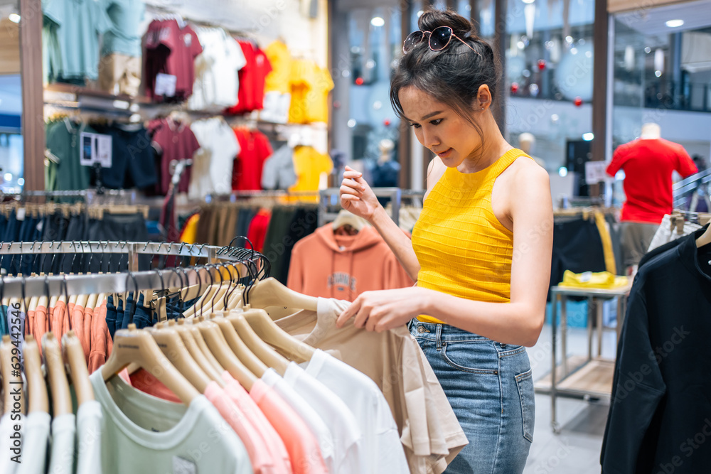 Asian young beautiful woman look products of clothes in shopping mall. 