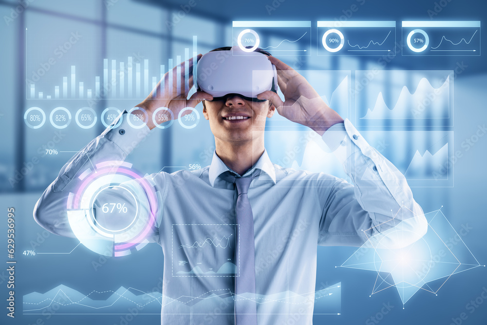 Attractive smiling young european businessman with VR glasses and glowing business chart hologram on