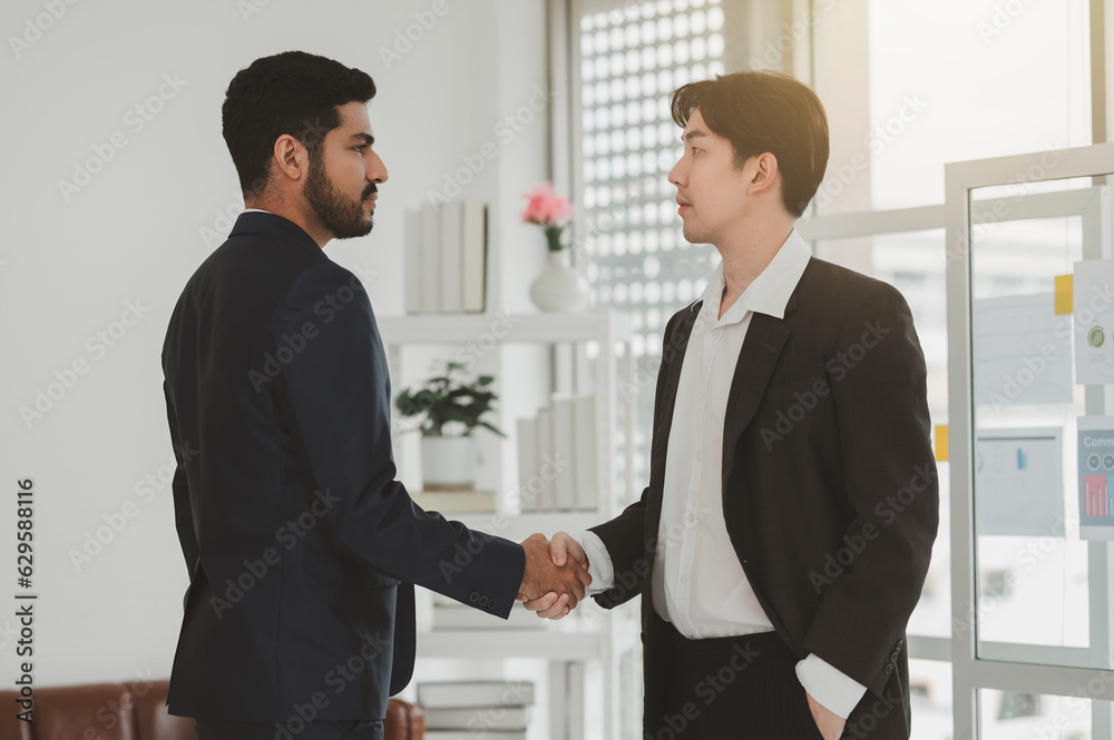 Two business men talking and rejoicing while working in the office