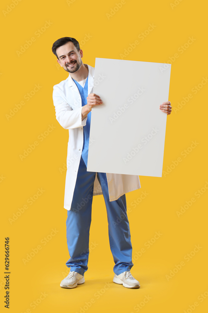 Male dentist with big plastic tooth on yellow background