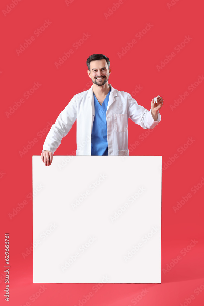 Male dentist with plastic tooth on red background