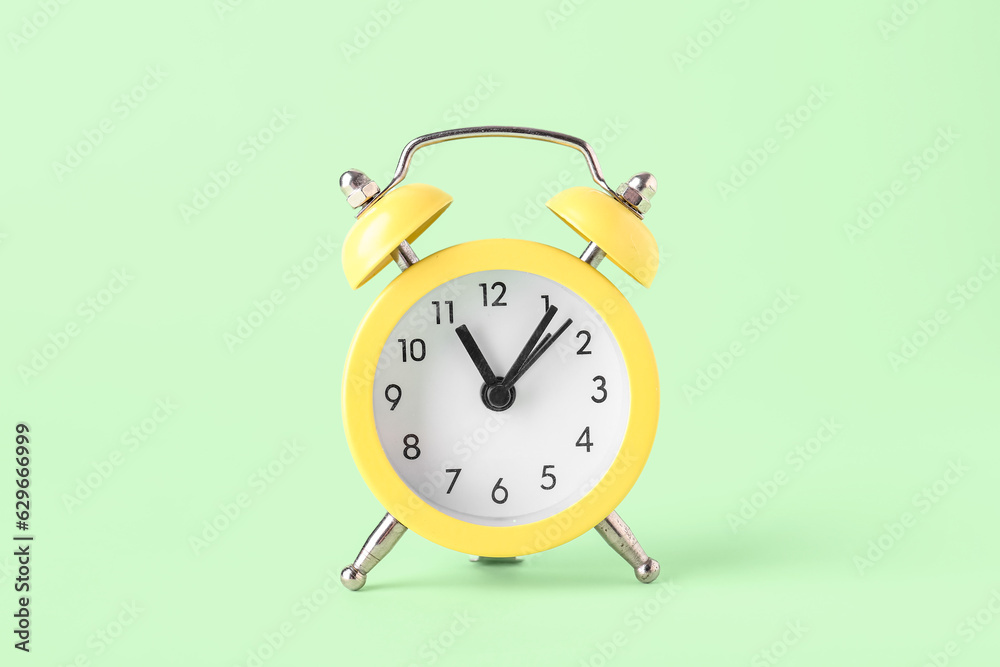 Yellow alarm clock on color background